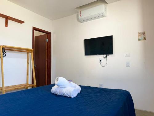 a stuffed animal is sitting on top of a bed at Brisa da Mata suítes BF in Baía Formosa