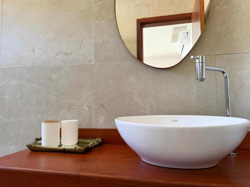 a bathroom with a white sink and a mirror at Brisa da Mata suítes BF in Baía Formosa
