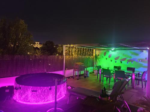 a patio with a table and a pool at night at ÁTICO RILQUE, Apartamentos Independientes con Jacuzzi Privado y Terraza en Ronda in Ronda