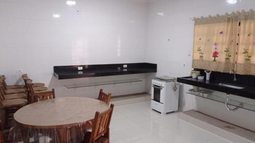 a kitchen with a table and a sink and a stove at Estância Bonanzza Barretos in Barretos