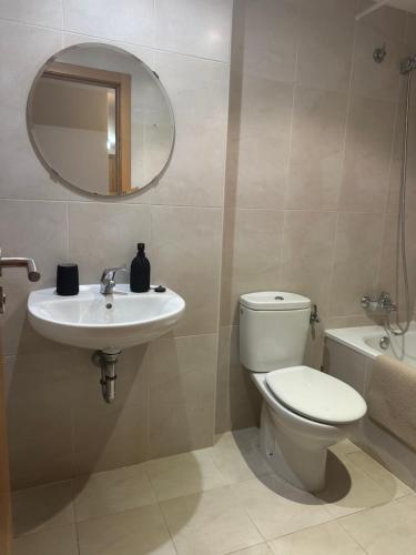a bathroom with a toilet and a sink and a mirror at Refugio PIRENAICO in Sabiñánigo