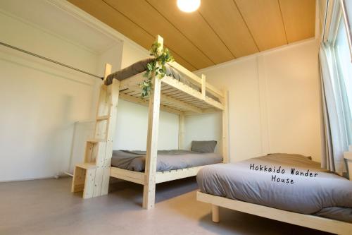 a bedroom with two bunk beds in a room at Hokkaido Wander House in Ashibetsu