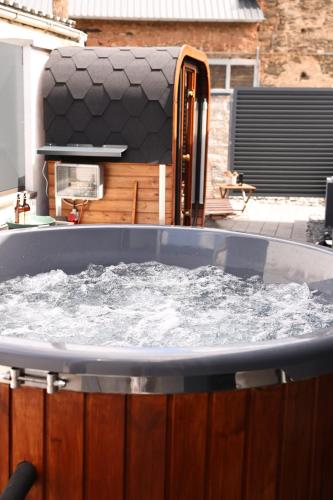 eine große, mit Wasser gefüllte Wanne in einem Garten in der Unterkunft Glamping L tiny , 2Ferienhäuser mit stillvolles Design und hohem Komfort Sauna Hot Tub in Platten