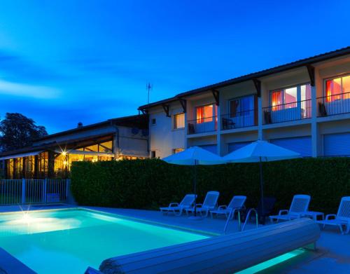 a swimming pool in front of a building with chairs and umbrellas at Logis Hôtel restaurant Horizon 117 in Sentaraille