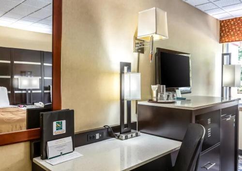 a hotel room with a desk with a computer and a bed at Quality Inn East Stroudsburg - Poconos in East Stroudsburg