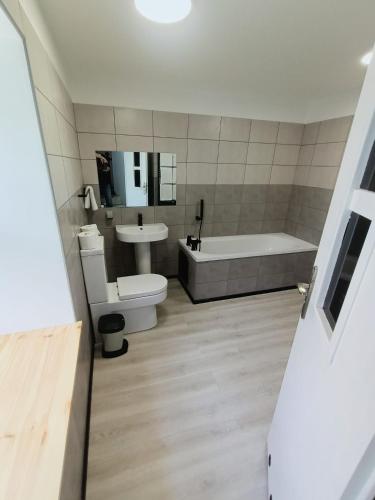 a bathroom with a tub and a toilet and a sink at The Old Surgery in Blaenau-Ffestiniog