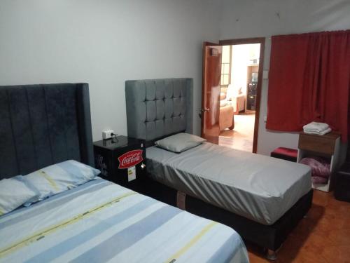 a bedroom with two beds and a door to a room at HotelesR20 in Lima