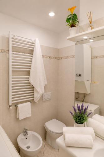 a white bathroom with a toilet and a sink at Casa DELUXE -50m dal mare- in Alassio