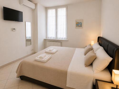 a bedroom with a large bed with two towels on it at Casa DELUXE -50m dal mare- in Alassio