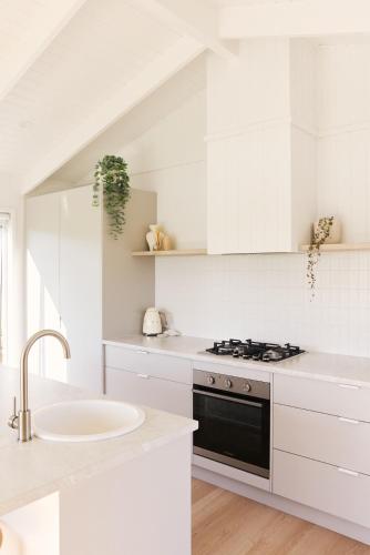 a white kitchen with a sink and a stove at Drift, Port Campbell in Port Campbell