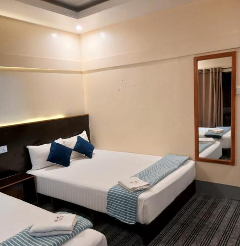 a hotel room with two beds and a mirror at Jolpoddo Retreat in Sreemangal