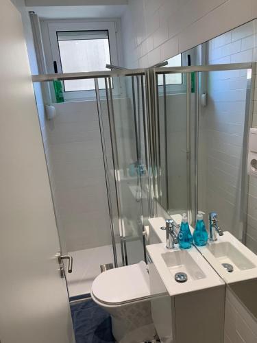 a bathroom with a toilet and a sink and a shower at Dormitorio no Porto in Porto
