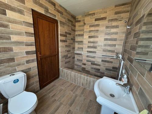 a bathroom with a toilet and a sink and a tub at Sargis guest house in Ushi