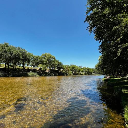 a river with trees on the side of it at Complejo Inti Wara - frente al Río Los Reartes in Los Reartes