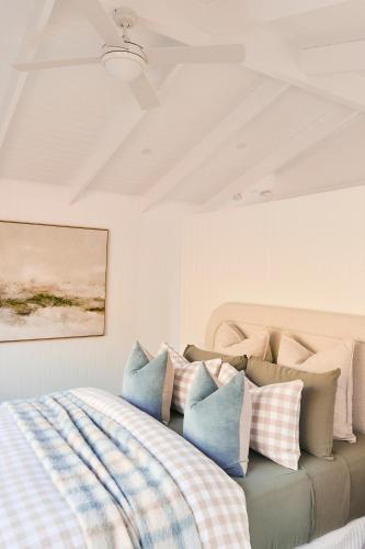 a bedroom with a bed with blue and white pillows at Drift, Port Campbell in Port Campbell