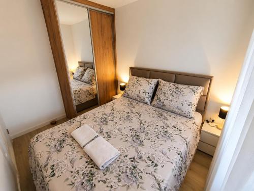 a small bedroom with a bed and a mirror at Tulipan LUX in Doboj