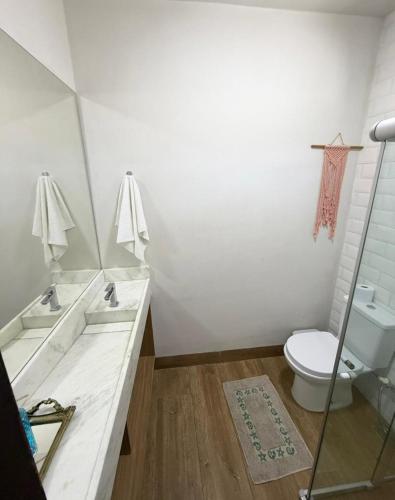 a white bathroom with a toilet and a sink at Chalé Brisa da Mata Baia Formosa in Baía Formosa