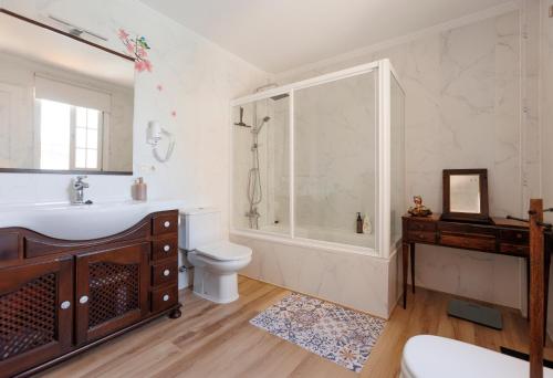 a bathroom with a sink and a shower and a toilet at Lumae Guesthouse in Lobres