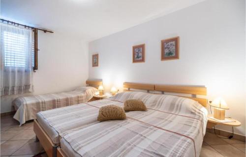 a bedroom with two beds and two tables and a window at Apartment Viola - Pavićini, Duga Uvala in Krnica