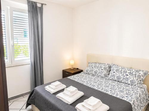 a white bedroom with a bed with towels on it at Casa Mansi in Vietri sul Mare