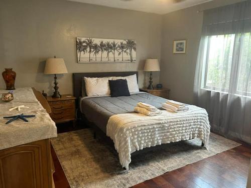 a bedroom with a bed with two tables and a window at Blue Beach Pool House in Port Orange