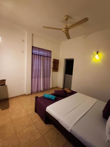 a bedroom with two beds and a ceiling fan at Sunset Paradise Talalla in Talalla South