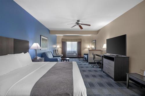 a hotel room with a large bed and a desk at Best Western Geneseo Inn in Geneseo