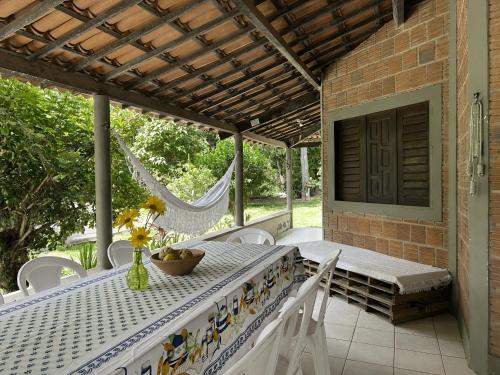 a patio with a table and chairs on a porch at Refúgio na Serra à 15min do Centro in Crato