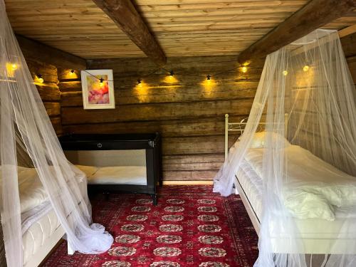 a bedroom with two beds with mosquito nets at Kolin Mattila B&B in Kolinkylä