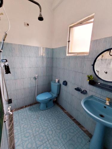 a bathroom with a blue toilet and a sink at Sunset Paradise Talalla in Talalla South