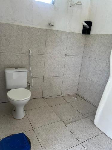 ein Badezimmer mit Toilette in einem gefliesten Raum in der Unterkunft Chácara in Conde