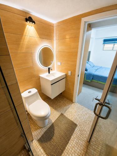 a bathroom with a toilet and a sink and a mirror at Apartamento vacacional pampatar in Pampatar
