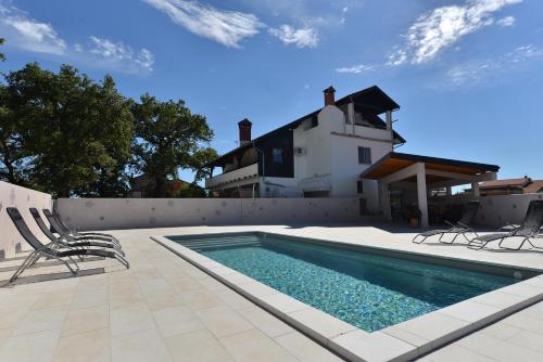 a swimming pool in front of a house at Villa Paolija in Novigrad Istria