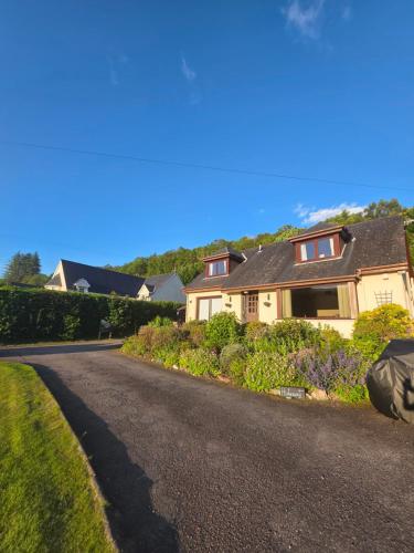 a house on a street with a driveway at The Hideaway Guest suite in Fort William