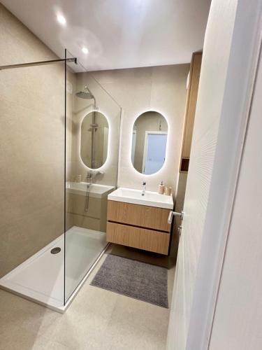 a bathroom with a shower and a sink and a mirror at Apartmani Eterović in Baška Voda