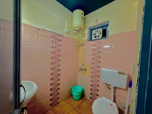 a pink bathroom with a toilet and a sink at Friends By Alizeh 2 0 Mcleodganj in Dharamshala