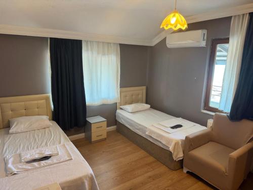 a hotel room with two beds and a chair at Kalmuk Apartment Hotel in Trabzon
