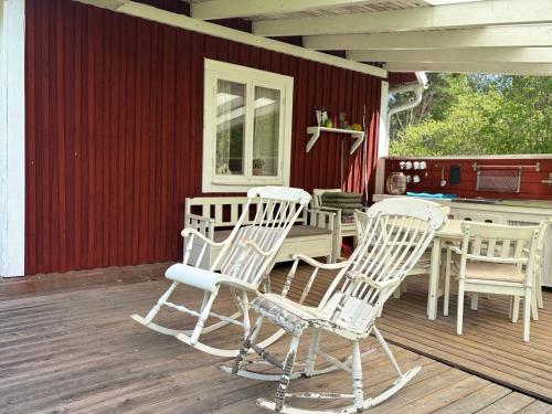 a group of chairs and a table on a porch at Hus Kråksmåla in Alsterbro