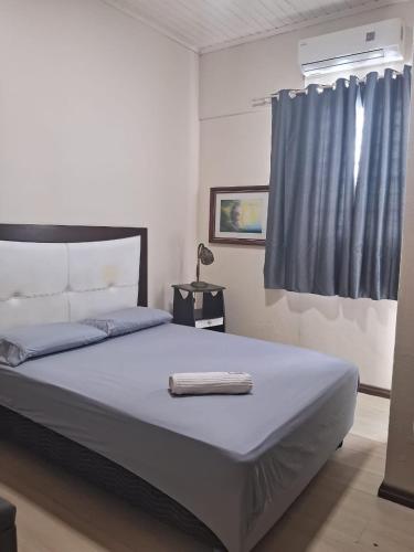 a bedroom with a large bed with a blue curtain at Ground floor apartment steps from the Cathedral in Santo Ângelo