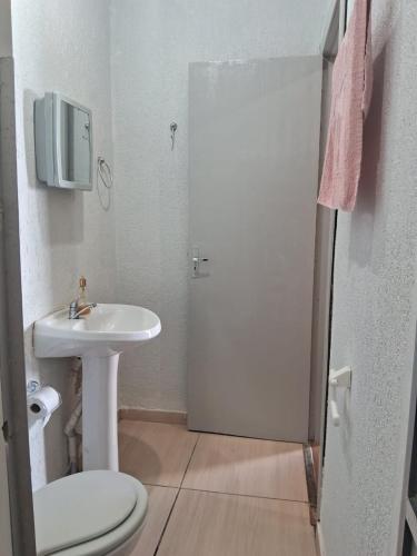 a white bathroom with a sink and a toilet at Ground floor apartment steps from the Cathedral in Santo Ângelo