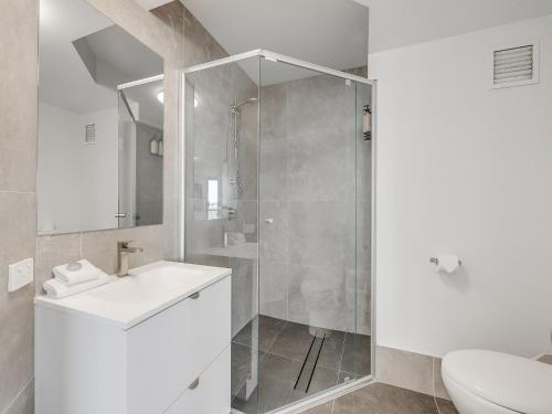 a bathroom with a shower and a sink and a toilet at Nautilus Private Rooftop Spa in Mooloolaba