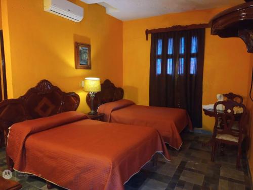 a hotel room with two beds and a window at Hotel Tlacotalpan in Tlacotalpan