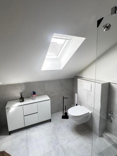 ein weißes Badezimmer mit Toilette und Oberlicht in der Unterkunft Studio No 1 in Heinsberg