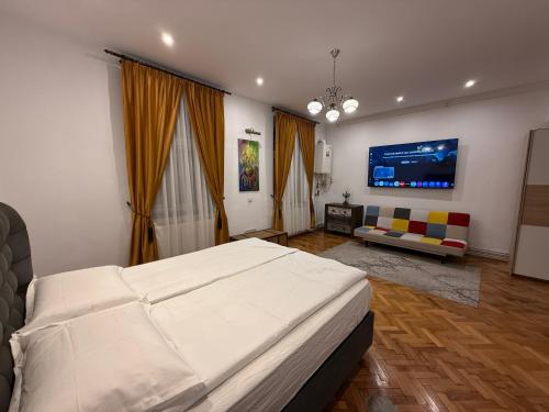 a bedroom with a large white bed and a couch at Insieme Studio - Small Square in Sibiu