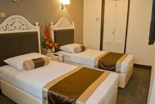 a hotel room with two beds in a room at The Inn at Temple Street in Singapore