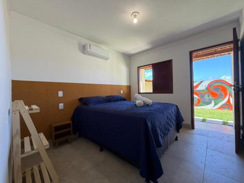 a bedroom with a blue bed and a window at Brisa da Mata Suítes BF quarto 02 in Baía Formosa