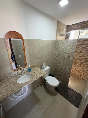 a bathroom with a sink and a toilet and a mirror at Brisa da Mata Suítes BF quarto 02 in Baía Formosa