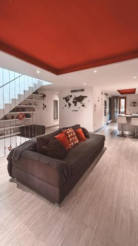 a large couch in a living room with a staircase at NURAS - Casa degli Anemoni in Porto Conte