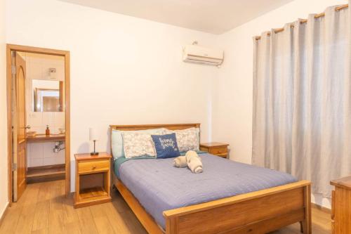 a bedroom with a bed with a stuffed animal on it at Chango's Apartments in Bocas Town