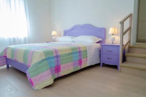 a bedroom with a purple bed with a colorful bedspread at Alloggi Agrituristici Le Vignole in Cordignano